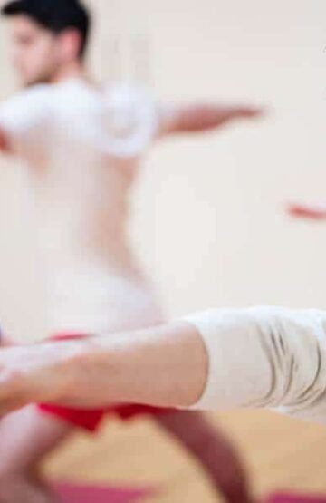 Group of people performing stretching exercise in the fitness studio